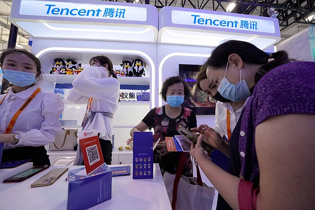 A woman is seen at the Tencent booth during a trade-in services fair in Beijing in September 2021. Stocks for the Chinese social media and gaming company Tencent, dropped after the company reported its slowest ever revenue growth.
Mandatory Credit:	Ng Han Guan/AP