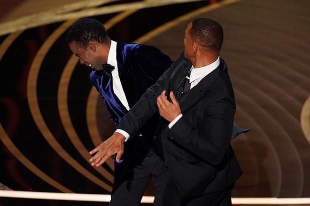 Will Smith, right, hits presenter Chris Rock on stage at the Oscars on Sunday. Rock will not be pressing charges against Smith following their onstage altercation.
Mandatory Credit: Chris Pizzello/Invision/AP