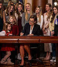 Florida isn't the only state pushing legislation that could be harmful to LGBTQ students. Iowa Gov. Kim Reynolds signs House File 2416 at The Iowa State Capitol in Des Moines, Iowa.
Mandatory Credit:	Nick Rohlman/The Gazette via AP