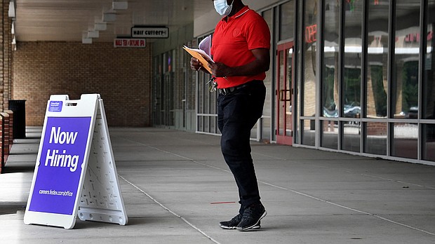Pedestrians walk by a "Now Hiring" sign outside a store in August 2021 in Arlington, Virginia. US businesses had 11.3 million job openings to fill in February.
Mandatory Credit:	Olivier Douliery/AFP/Getty Images