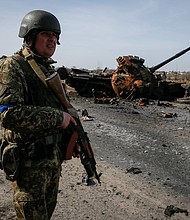 A Ukrainian serviceman stands near the wreck of a Russian tank on the front lines in the Kyiv region, Ukraine on March 28.
Mandatory Credit:	Gleb Garanich/Reuters