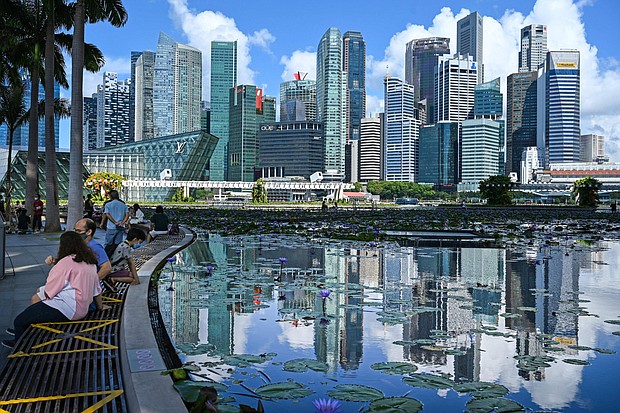 This photograph taken on June 14, 2021, shows people sitting next to a pond with a view of the skyline in Singapore.
Mandatory Credit:	Roslan Rahman/AFP via Getty Images