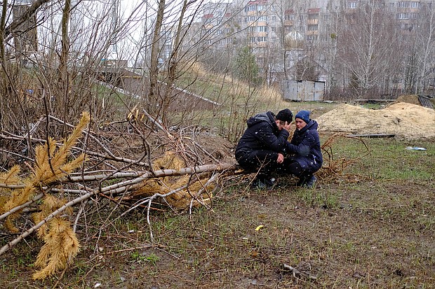 Vladimir is comforted by his wife, Anna, near the mass grave in Bucha.
Mandatory Credit:	Vasco Cotovio/CNN