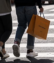 A pedestrian carries a Louis Vuitton shopping bag in San Francisco in September 2021. Higher prices and geopolitical concerns may soon slow demands for luxury goods.
Mandatory Credit:	David Paul Morris/Bloomberg/Getty Images