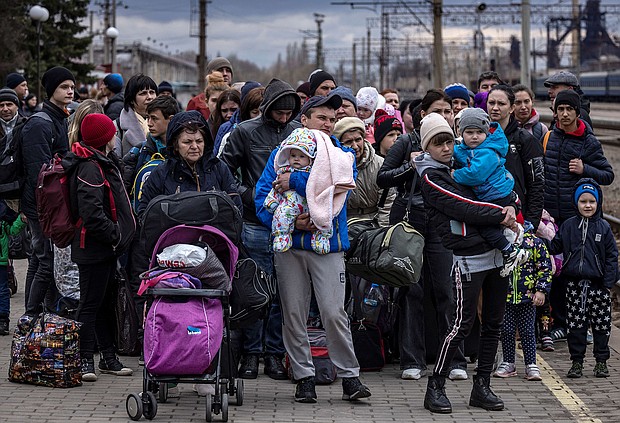 Families arrive at the main train station as they flee the eastern city of Kramatorsk, in the Donbass region on April 4, 2022, amid Russian invasion of Ukraine.