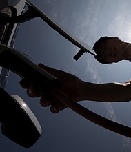 Seen here is a man charging a hybrid Chevrolet in Jeju, South Korea, in June 2017. General Motors and Honda announced on April 5 that they'd be teaming up to build a $30k electric car.
Mandatory Credit:	SeongJoon Cho/Bloomberg/Getty Images