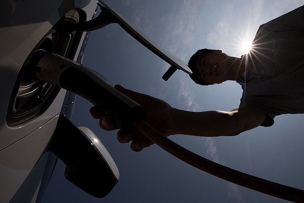 Seen here is a man charging a hybrid Chevrolet in Jeju, South Korea, in June 2017. General Motors and Honda announced on April 5 that they'd be teaming up to build a $30k electric car.
Mandatory Credit:	SeongJoon Cho/Bloomberg/Getty Images