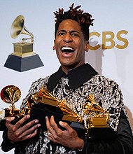 Jon Batiste poses in the press room at the MGM Grand Garden Arena with the five Grammy Awards he won Sunday at the 64th Annual Grammy Awards in Las Vegas. He won for best American roots performance for “Cry;” best American roots song for “Cry;” best music video for “Freedom;” best score soundtrack for visual media for “Soul;” and album of the year for “We Are.”