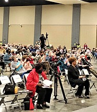 Audience members applaud as RISC Co-President Don Coleman speaks during the coalition’s annual Nehemiah Conference Tuesday evening at the Greater Richmond Convention Center. On the platform with him are Richmond City Council member Stephanie A. Lynch and James “Jim” Holland, a member of the Chesterfield County Board of Supervisors.