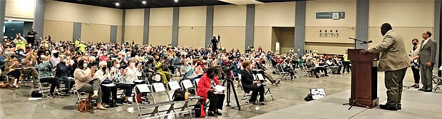 Audience members applaud as RISC Co-President Don Coleman speaks during the coalition’s annual Nehemiah Conference Tuesday evening at the Greater Richmond Convention Center. On the platform with him are Richmond City Council member Stephanie A. Lynch and James “Jim” Holland, a member of the Chesterfield County Board of Supervisors.