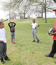 It’s spring break for Henrico brothers Neal Joyner, 9, left; his brother, Nasir Joyner, 6, center; and their cousin, Isaiah Banks, 11, of Chesterfield. But the three were “working out” Tuesday at Byrd Park with their grandfather and coach, Ronnie Harris. They were having fun running to catch their grandfather’s long passes on the grassy stretch by Fountain Lake. Mr. Harris played neighborhood football growing up, while one of the boys played for the Kanawha Red Hawks, a pee-wee team in Henrico. (Regina H. Boone/Richmond Free Press)