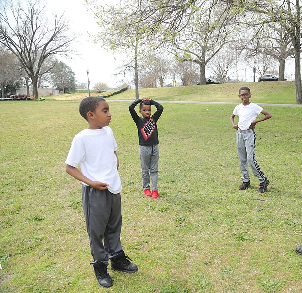 It’s spring break for Henrico brothers Neal Joyner, 9, left; his brother, Nasir Joyner, 6, center; and their cousin, Isaiah Banks, 11, of Chesterfield. But the three were “working out” Tuesday at Byrd Park with their grandfather and coach, Ronnie Harris. They were having fun running to catch their grandfather’s long passes on the grassy stretch by Fountain Lake. Mr. Harris played neighborhood football growing up, while one of the boys played for the Kanawha Red Hawks, a pee-wee team in Henrico. (Regina H. Boone/Richmond Free Press)