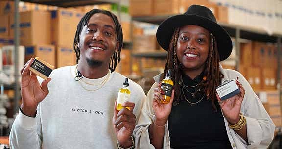 Herb’N Eden owners Quinton (left) and Terran Lewis (right) holding their all-natural products. PRNewsFoto.