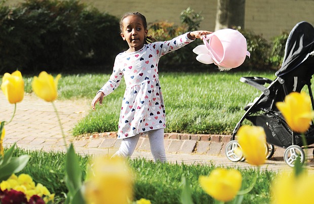 Lydia Bayou, 4, of Glen Allen looks to fill her Easter basket Monday during an Easter egg hunt hosted by Gov. Glenn A. Youngkin and First Lady Suzanne S. Youngkin outside the Executive Mansion in Capitol Square in Downtown. The seasonal event was for the staff of the Children’s Hospital of Richmond and their children. Lydia was accompanied by her parents, Fisseha Bayou and Miheret Yitayew, and her 6-year-old brother, Aaron Bayou.