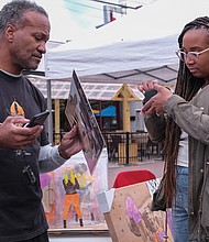 Richmond’s 17th Street Market was filled with art and music last Saturday with the kickoff of the RVA Night Market. More than 30 vendors sold arts and other wares, including Todd Parsons, who sells a painting to Quinn Tucker.