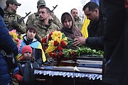 Relatives and friends stand by the coffins of Ukrainian servicemen Yuri Filyuk, 49, and Oleksander Tkachenko, 33, during a funeral ceremony Tuesday in a village of Oleksandrivka, Odesa region, Ukraine. According to Ukrainian servicemen, these two were killed when a Russian missile hit their military base in Krasnoselka, Odesa region, on April 7.
