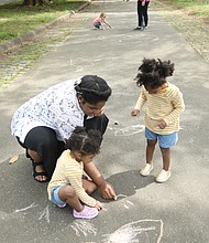 Courtney Johnson of Hopewell and her 2-year-old twins, Jayla and Leila, get creative with pastel sidewalk chalk on one of Maymont’s long walkways. They found a quiet space among the crowd to draw happy faces and other figures.