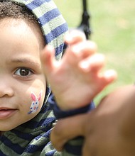 Two-year-old Ashton Adams shows the little bunny painted on his cheek as he sat on a tractor under the watchful eye of his mother, Aldea Hayes. Farm, fire, rescue and utility equipment of all sizes were on display for youngsters to enjoy.