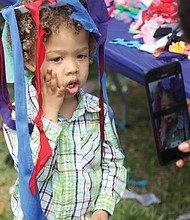 Esther Howard turns her son Levi’s moment into memories as she photographs the 3-year-old wearing the Easter creation he fashioned from streamers. The Howard family, including dad and 10-month-old sister Edin, drove down from Stafford to attend the event.