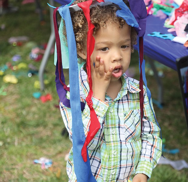 Esther Howard turns her son Levi’s moment into memories as she photographs the 3-year-old wearing the Easter creation he fashioned from streamers. The Howard family, including dad and 10-month-old sister Edin, drove down from Stafford to attend the event.