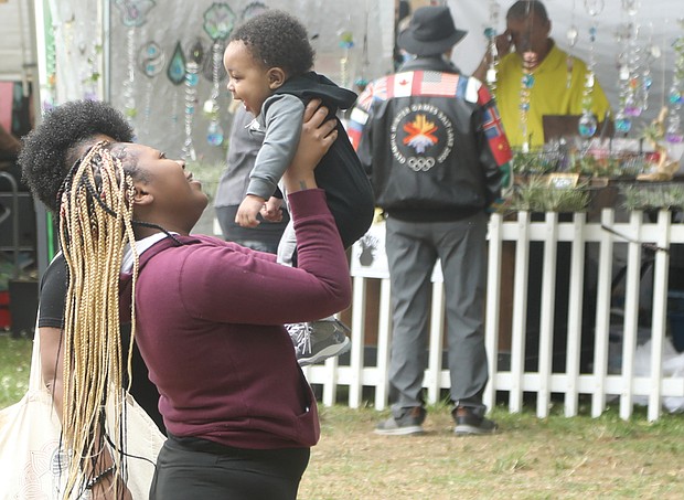 Five-month-old Royal Smith giggles as his grandmother, Deanna Casey, lifts him high at Arts in the Park at The Carillon in Byrd Park. The infant enjoyed the stroll to look at artwork with his grandmother and mother, D’Asia Hill. Thousands of people flocked to the festival that returned after a two-year hiatus because of the pandemic.