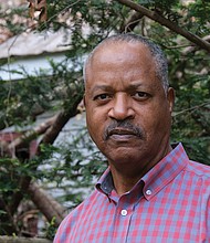 Retired FBI executive Mike Mines stands outside the cabin that once housed enslaved people at The Meadows in Caroline County.