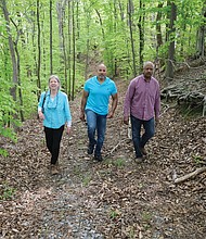 Kate Tweedy leads Mike Mines, right, and his brother, William Mines Jr., through the area where people who were enslaved at The Meadows are believed to be buried, including members of the Mines family who were horse groomers and worked on the plantation.