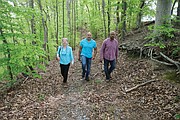 Kate Tweedy leads Mike Mines, right, and his brother, William Mines Jr., through the area where people who were enslaved at The Meadows are believed to be buried, including members of the Mines family who were horse groomers and worked on the plantation.