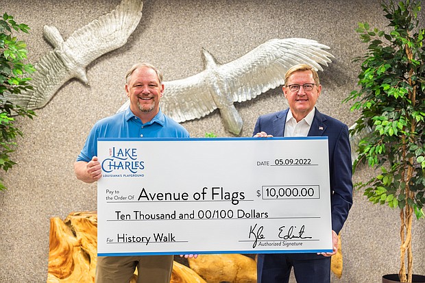 Kyle Edmiston, President/CEO of Visit Lake Charles, presents a $10,000 grant to Ted Harless, Jr., Director of the Avenue of Flags, to enhance the biannual event with the History Walk that will debut at the 2022 Avenue of Flags’ Memorial Day display.