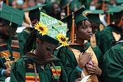 Makayla Taylor, left, and Searra Wiggins intently follow the commencement program.