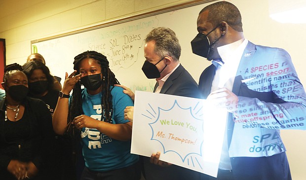 Kiara S. Thompson, an eighth-grade physical science teacher at Boushall Middle School, breaks into tears as she is surprised May 6 in her classroom by Superintendent Jason Kamras, second from right, and Mayor Levar M. Stoney, with their announcement that she was selected Richmond’s Teacher of the Year.