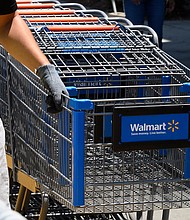 An employee gathers shopping carts at Walmart in July 2020 in Burbank, California. Walmart is creating a new program to fast-track recent college graduates into store manager positions.
Mandatory Credit:	Robyn Beck/AFP/Getty Images