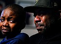 Wayne Jones holds his son Donell, while speaking during an interview with The Associated Press about his mother Celestine Chaney, who was killed in Saturday's shooting at a supermarket, in Buffalo, N.Y.  (AP photo)
