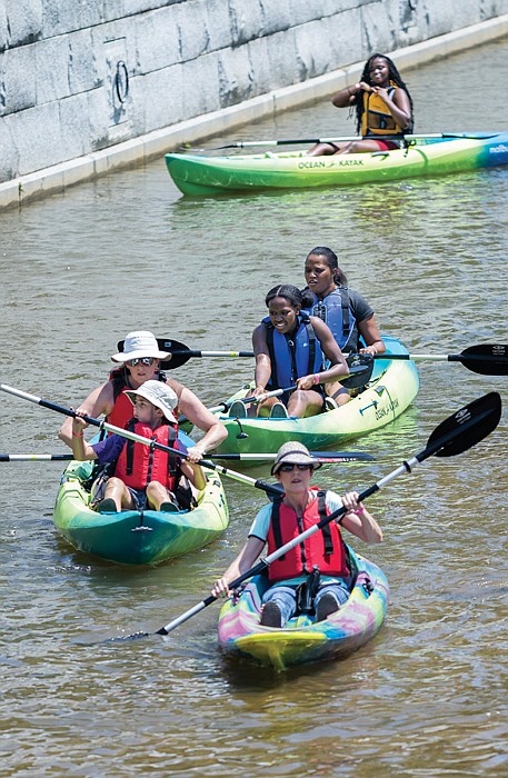 Festival-goers paddle around in the canal at Tredegar Street during Dominion Energy Riverrock’s “Try A Kayak” activity last Saturday.