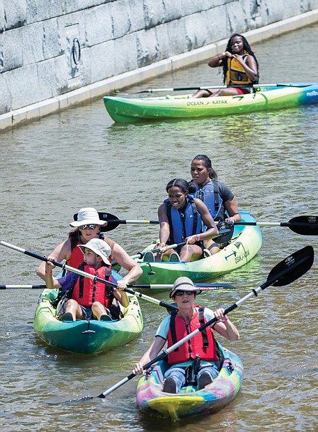 Festival-goers paddle around in the canal at Tredegar Street during Dominion Energy Riverrock’s “Try A Kayak” activity last Saturday.
