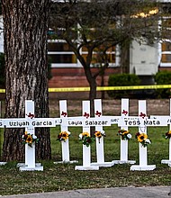 Police officers walk past a makeshift memorial for the shooting victims at Robb Elementary School in Uvalde, Texas, on Thursday.
Mandatory Credit:	Chandan Khanna/AFP/Getty Images