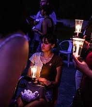 A young woman holds a candle during a candlelight vigil to honor and remember the victims of the mass shooting in Uvalde, Texas on May 30.
Mandatory Credit:	Chandan Khanna/AFP/Getty Images