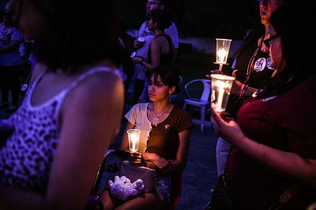 A young woman holds a candle during a candlelight vigil to honor and remember the victims of the mass shooting in Uvalde, Texas on May 30.
Mandatory Credit:	Chandan Khanna/AFP/Getty Images