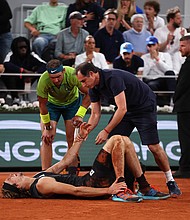 Alexander Zverev of Germany receives medical attention as Rafael Nadal of Spain looks on Friday in the men's semifinal match at the French Open.
Mandatory Credit:	Clive Brunskill/Getty Images