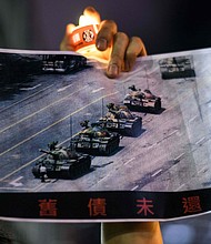 A man holds a poster of the famous 'Tank Man' who stood in front of Chinese military tanks at Tiananmen Square in Beijing in 1989.
Mandatory Credit:	Anthony Wallace/AFP/Getty Images