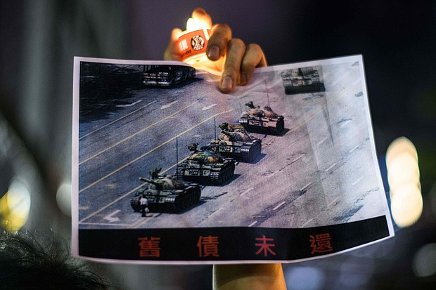 A man holds a poster of the famous 'Tank Man' who stood in front of Chinese military tanks at Tiananmen Square in Beijing in 1989.
Mandatory Credit: Anthony Wallace/AFP/Getty Images