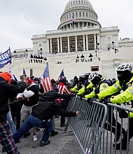 Violent insurrectionists loyal to then-President Donald Trump break through a police barrier at the Capitol in Washington on January 6, 2021.
Mandatory Credit:	Julio Cortez/AP