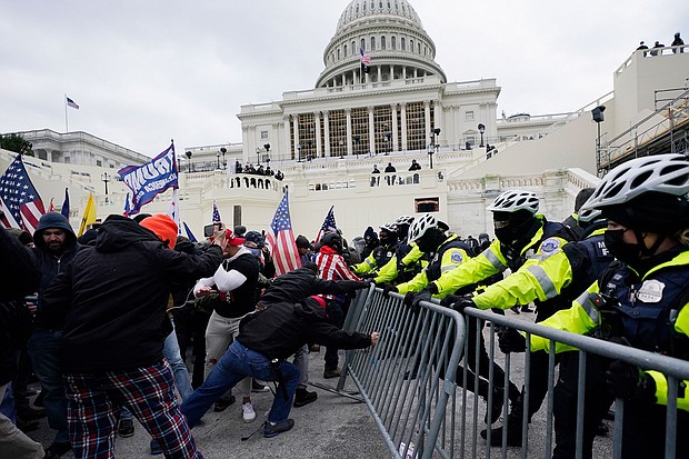 Violent insurrectionists loyal to then-President Donald Trump break through a police barrier at the Capitol in Washington on January 6, 2021.
Mandatory Credit:	Julio Cortez/AP