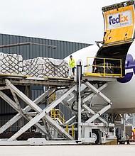 Workers unload a FedEx Express cargo plane carrying infant formula as a Secret Service agent stands watch at Dulles international airport in Dulles, Virginia, on May 25.
Mandatory Credit:	Eric Lee/The Washington Post/Getty Images