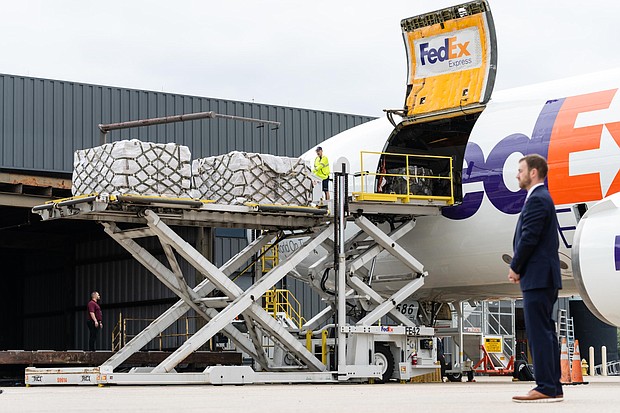 Workers unload a FedEx Express cargo plane carrying infant formula as a Secret Service agent stands watch at Dulles international airport in Dulles, Virginia, on May 25.
Mandatory Credit: Eric Lee/The Washington Post/Getty Images
