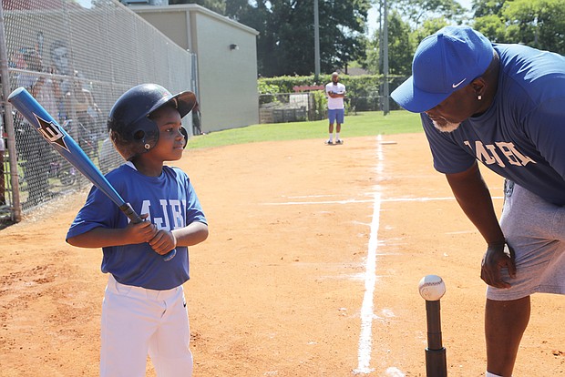 Coach Anthony Grigsby of Blackwell’s RVA Trojans gives batting tips to one of his T-Ball players, Miles Clay, 5, of Richmond last Saturday during the opening game of the Metropolitan Junior Baseball League’s 56th opening season.
