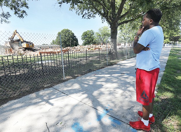 Sherman Washington, 31, of Richmond watches the demolition of the Creighton Court public housing community along Nine Mile Road in Richmond’s East End on Monday. He moved into the community when he was a 1-year-old. He left in 2008. “I’m just glad that it’s gone,” he said. “I’ll miss it though. I have a whole lot of memories. There was a whole lot going on out here. ... My son doesn’t have to live out here.”