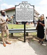 Mayor Levar M. Stoney takes part in unveiling new state history marker for the historic Shockoe Hill Burying Ground, the long forgotten public cemetery for 22,000 Black people at 1305 N. 5th St. at the entry to Highland Park. Joining the mayor at the ceremony Sunday afternoon are Ana F. Edwards of the Sacred Ground Historical Reclamation Project, left, and Lenora C. McQueen, a Texas resident who has led a four-year fight to preserve and protect the burial ground where relatives are buried and who has pushed for the cemetery’s recognition and designation as a national historic site.