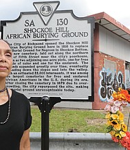 Ms. McQueen proudly stands in front of the new marker that she successfully lobbied the state Department of Historic Resources to install.