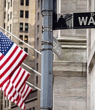 Fears of a recession and the Federal Reserve's aggressive rate hikes have pushed investors to dump corporate debt in recent weeks and pictured, the sign for Wall Street is seen with US flags outside the New York Stock Exchange in New York on June 16.
Mandatory Credit:	Yuki Iwamura/AFP/Getty Images/FILE
